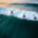 Aerial view of surfers riding waves with wind direction noted